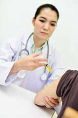 Asian female doctor prepare injection drug for patient  