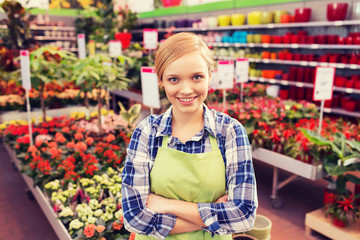 happy woman with flowers in greenhouse