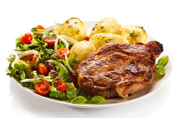 Grilled steaks, boiled potatoes and vegetable salad 