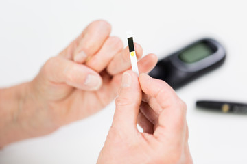 senior woman with glucometer checking blood sugar