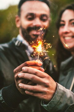 Young Adult Couple Celebrating with Sparklers Outdoors