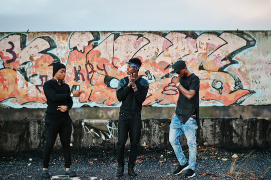Three rap singers band on the roof background graffiti wall