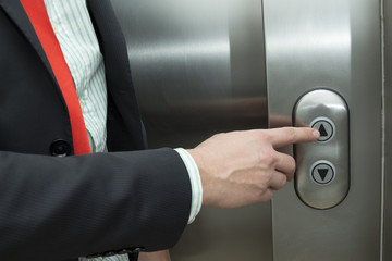 Businessman pressing elevator up button