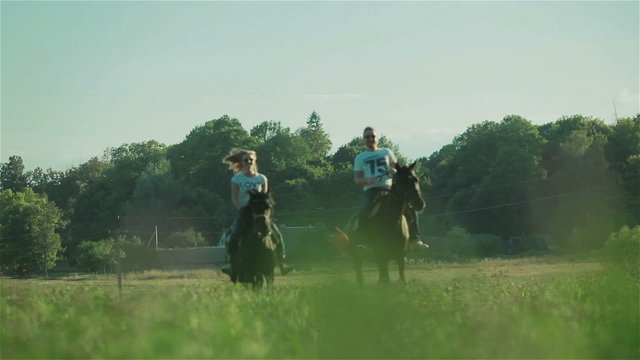 Happy young couple riding horses. Front view