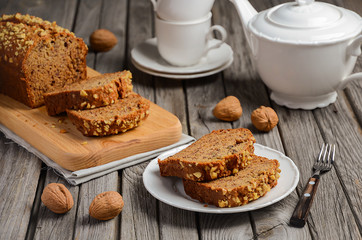 Banana bread with walnuts on the rustic wooden background