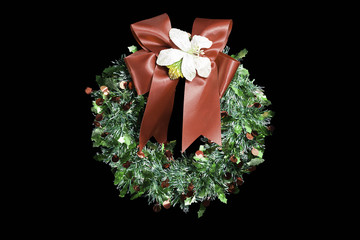 christmas wreath with red ribbon and golden decoration isolated on black