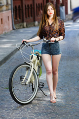 Fototapeta na wymiar Young girl with bicycle having fun on the street