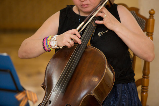 the woman plays a violoncello