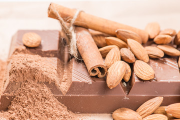 Close-up of still life: white and dark chocolate, almonds, cinna