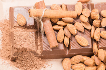 Close-up of still life: white and dark chocolate, almonds, cinna