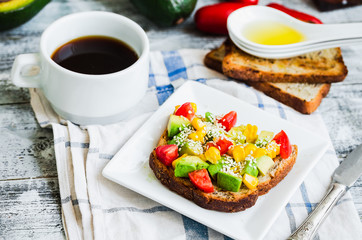 toast with fresh avocado, tomato and corn, a cup of coffee, brea