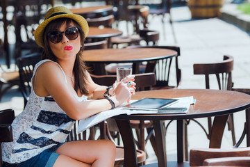 Funny young tourist woman sitting at the cafe