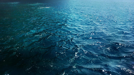 Blue deep sea waves with foam on the surface of water