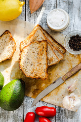 bread and a whole avocado with cherry tomatoes,top view