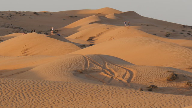 tourists in oman desert (Sharqiya Sand) known as wahiba sands during sunset 4K UHD mov