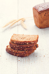  Loaf and slices of bread with spikelet of wheat on a boards