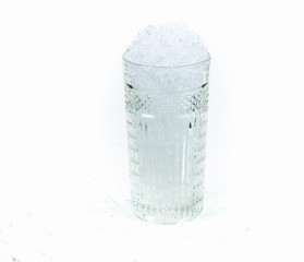 Tall cocktail glass with ice. White background. Refrigerated utensils