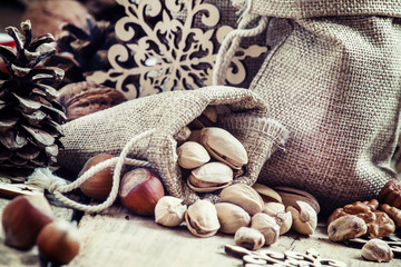 Walnuts, hazelnuts, pistachios in bags made of burlap, candy can