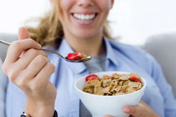 Beautiful young woman eating cereals at home. © nenetus