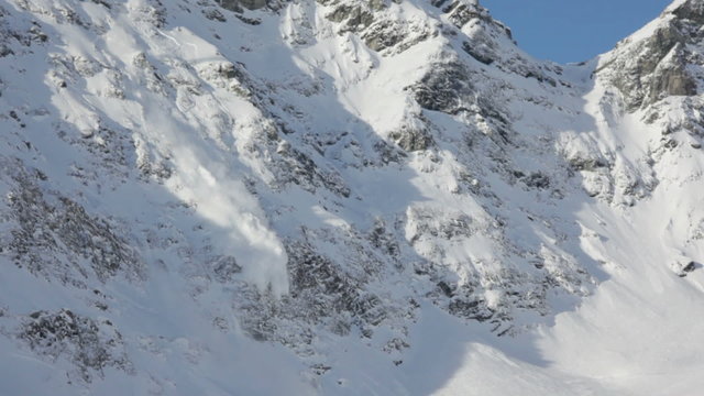 A dangerous avalanche going down from the mountain side reaching the ski slope. West italian Alps, Alagna, Italy.