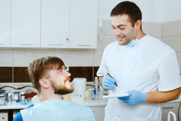 Obraz premium dentist taking notes with happy patient