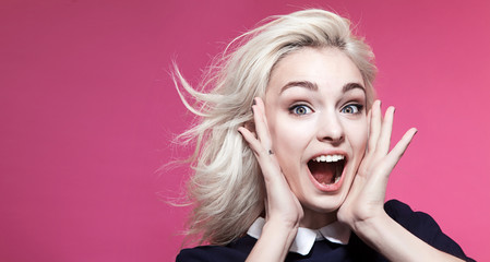 Cheerful girl fooling around on a pink background