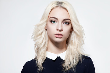 Portrait of a cute girl with beautiful hair in a black dress on a white background