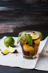 Cuba libre with lime on black wooden table