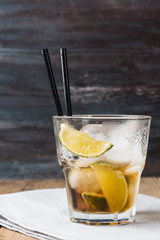 Cuba libre cocktail on the rustic background