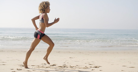 Fototapeta na wymiar Woman Running On The Beach