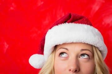 Woman looking up at her red Santa hat