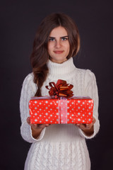 Beautiful brunette woman holding gift box