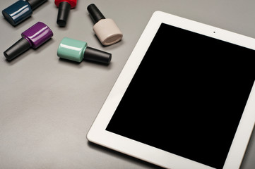 White tablet computer with nail polish