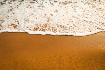  yellow sand and smooth ocean water with a bubbles