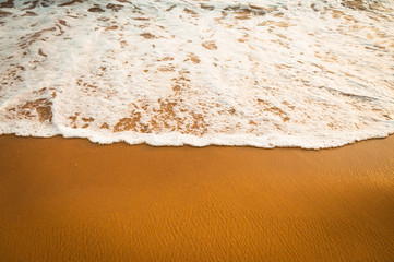  yellow sand and smooth ocean water with a bubbles