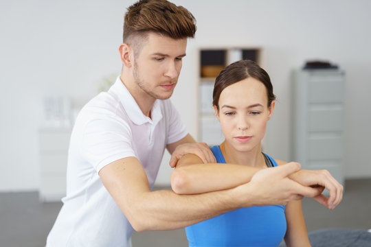 osteopath behandelt eine frau mit schmerzen am ellbogen
