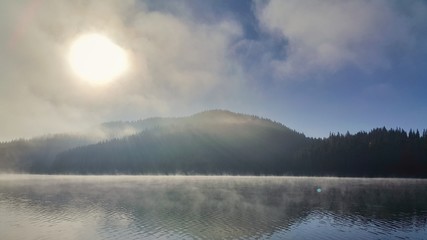 Sunrise with mystic fog over the lake