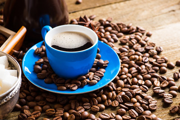 Coffee cup and saucer on a wooden table. Dark background, coffee