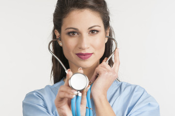 Female doctor holding up the disc of a stethoscope