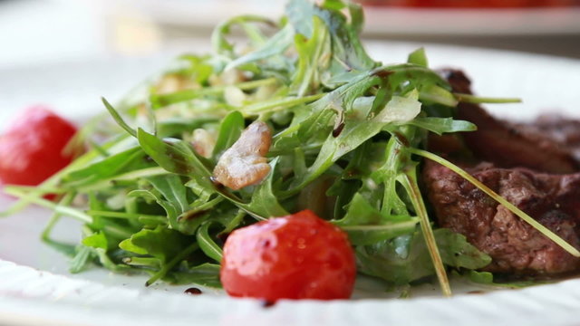 Presentation of Fresh food salad with ruccola cherry tomatoes and meat steak of beef