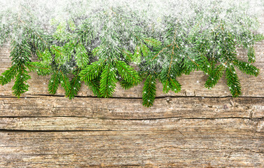 Christmas tree branches with snowflakes wooden background