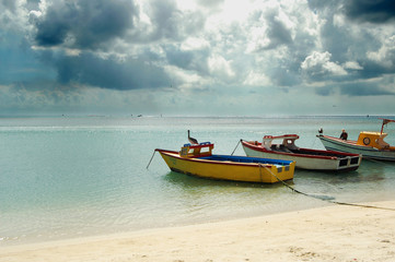 Naklejka na ściany i meble Perfect day at the beach in Aruba, boats on water.