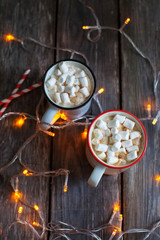 mug of coffee and marshmallows on the table with illumination