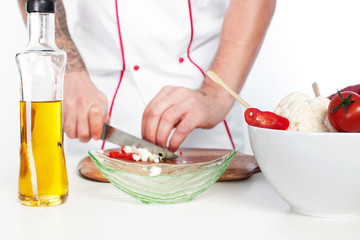 male chef dressed in white uniform cooking food