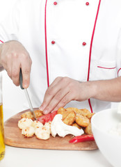 Obraz na płótnie Canvas male chef dressed in white uniform cooking food