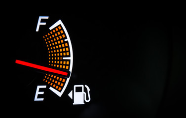 Fuel gauge on the black background - obrazy, fototapety, plakaty