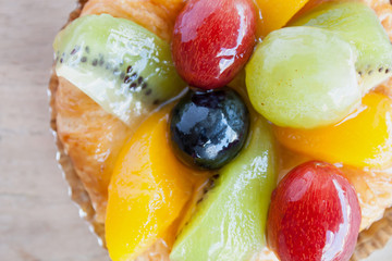 close up danish pastry with fruit on wood table