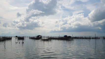 Fototapeta na wymiar Homestay and floating basket in lake at Kohyo, Songkhla, Thailand with beautiful sky and clouds. This is traditional fisheries area.
