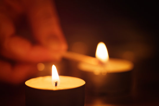 woman hand setting candle with beautiful out of focus