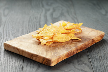 tortilla chips on olive wood board on wooden table